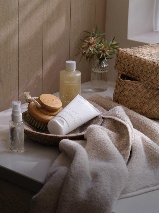 a bathroom counter with a white bag and a bottle of lotion