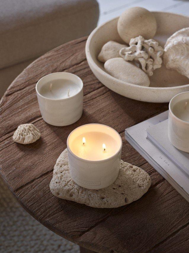 three candles are sitting on white boxes with labels on them