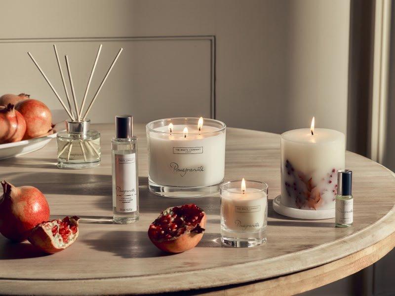 a table with a bunch of candles and pomegranates on it