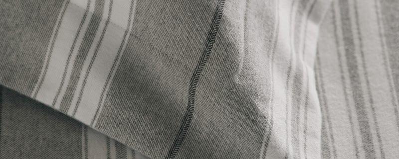a close up of a man wearing a black hat and a striped shirt