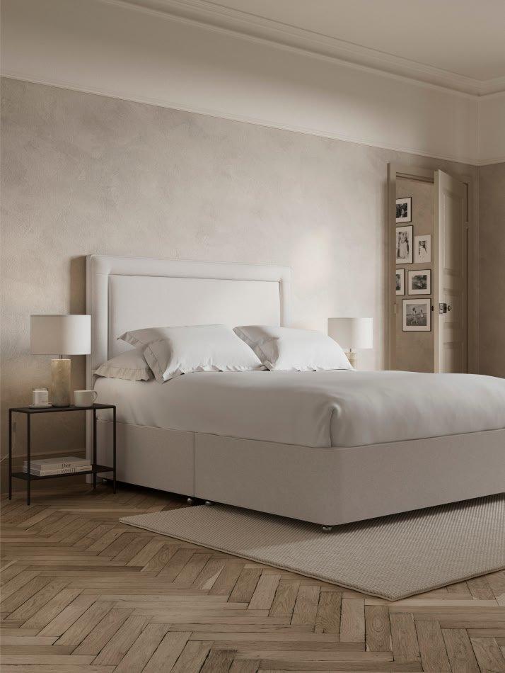 a white bed with a white headboard and white sheets