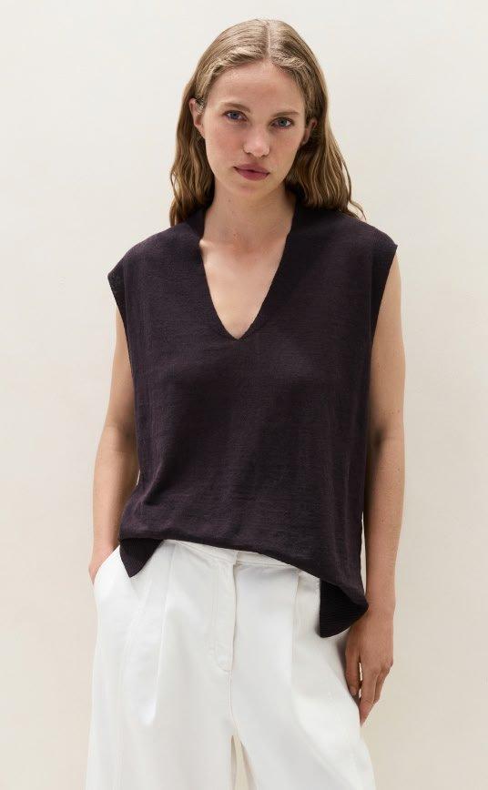 a woman in white pants and a black top
