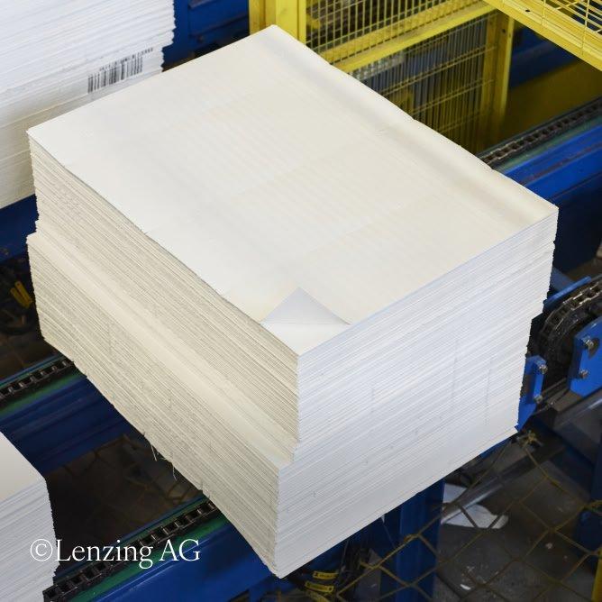 a stack of paper on a conveyor belt in a factory