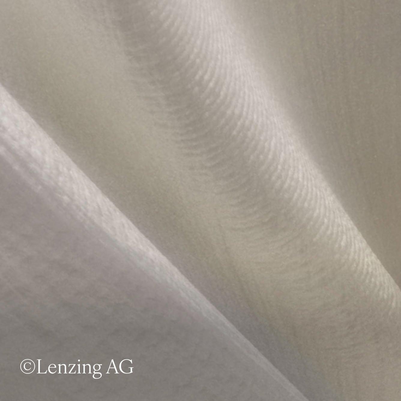 a close up of a white fabric with a white thread