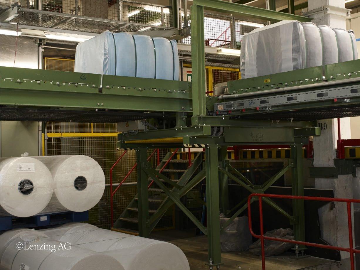 a factory with a conveyor belt and a bunch of rolls of paper