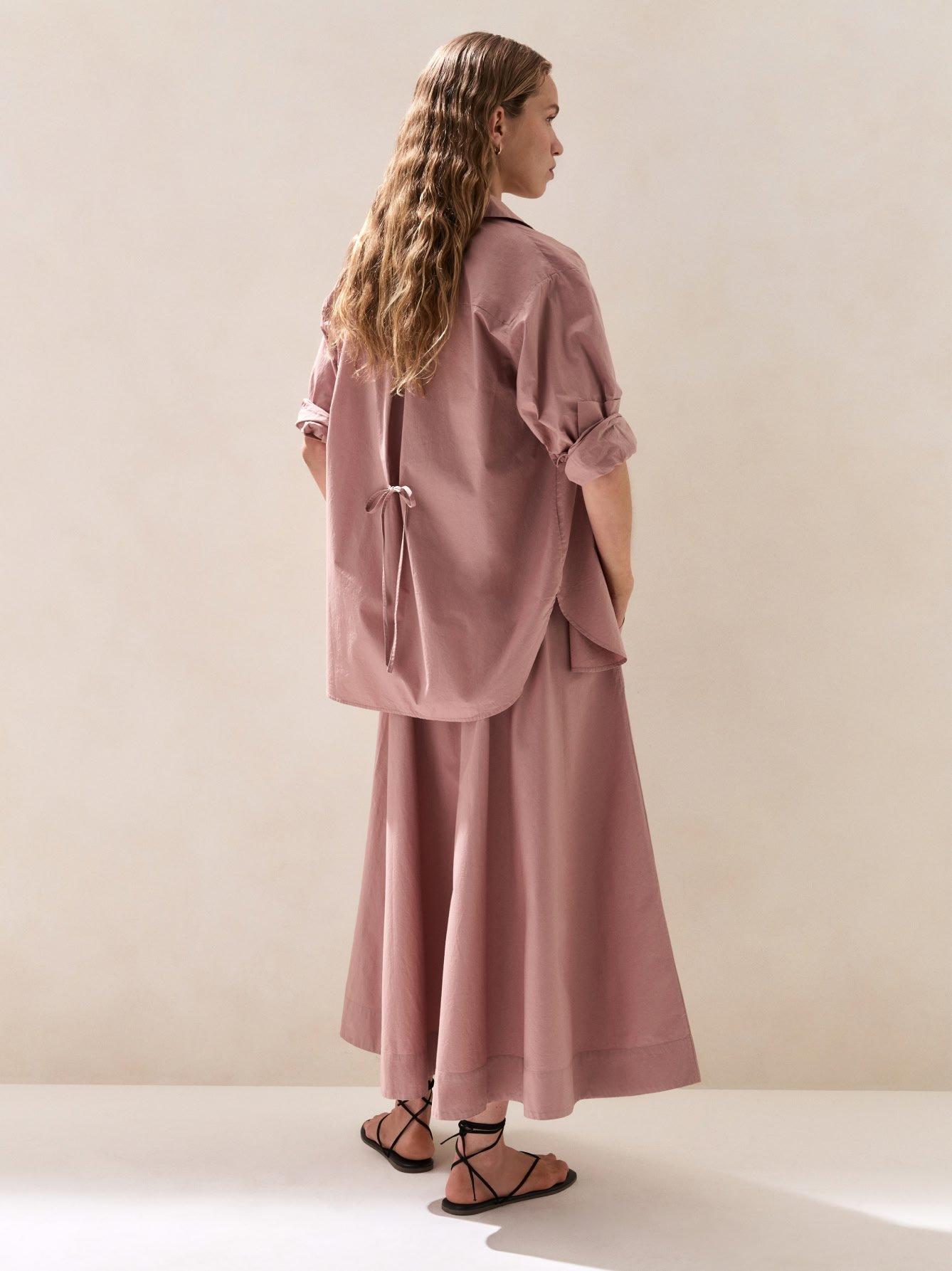 the back view of a woman wearing a pink dress