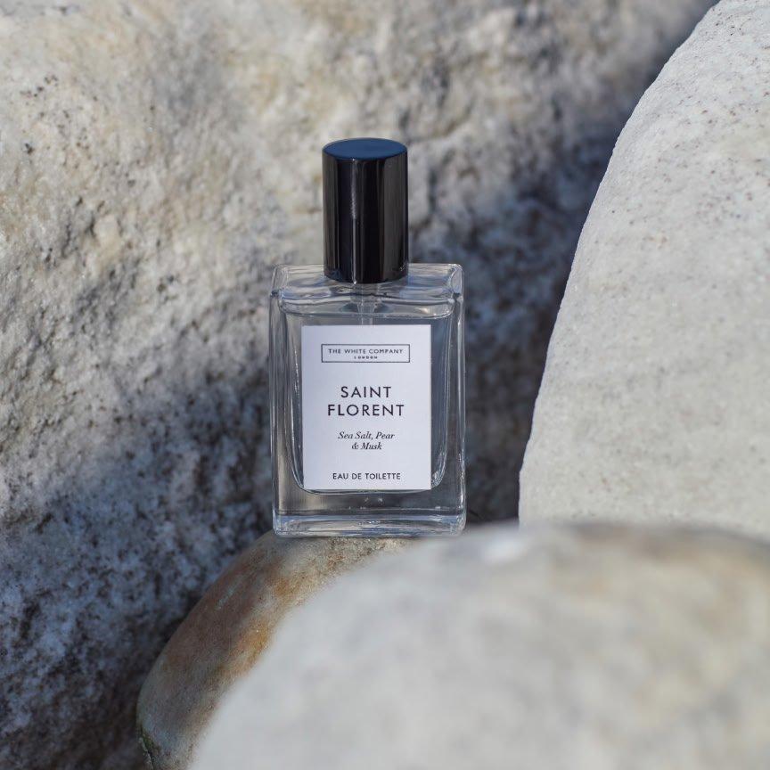 a bottle of perfume sitting on top of some rocks