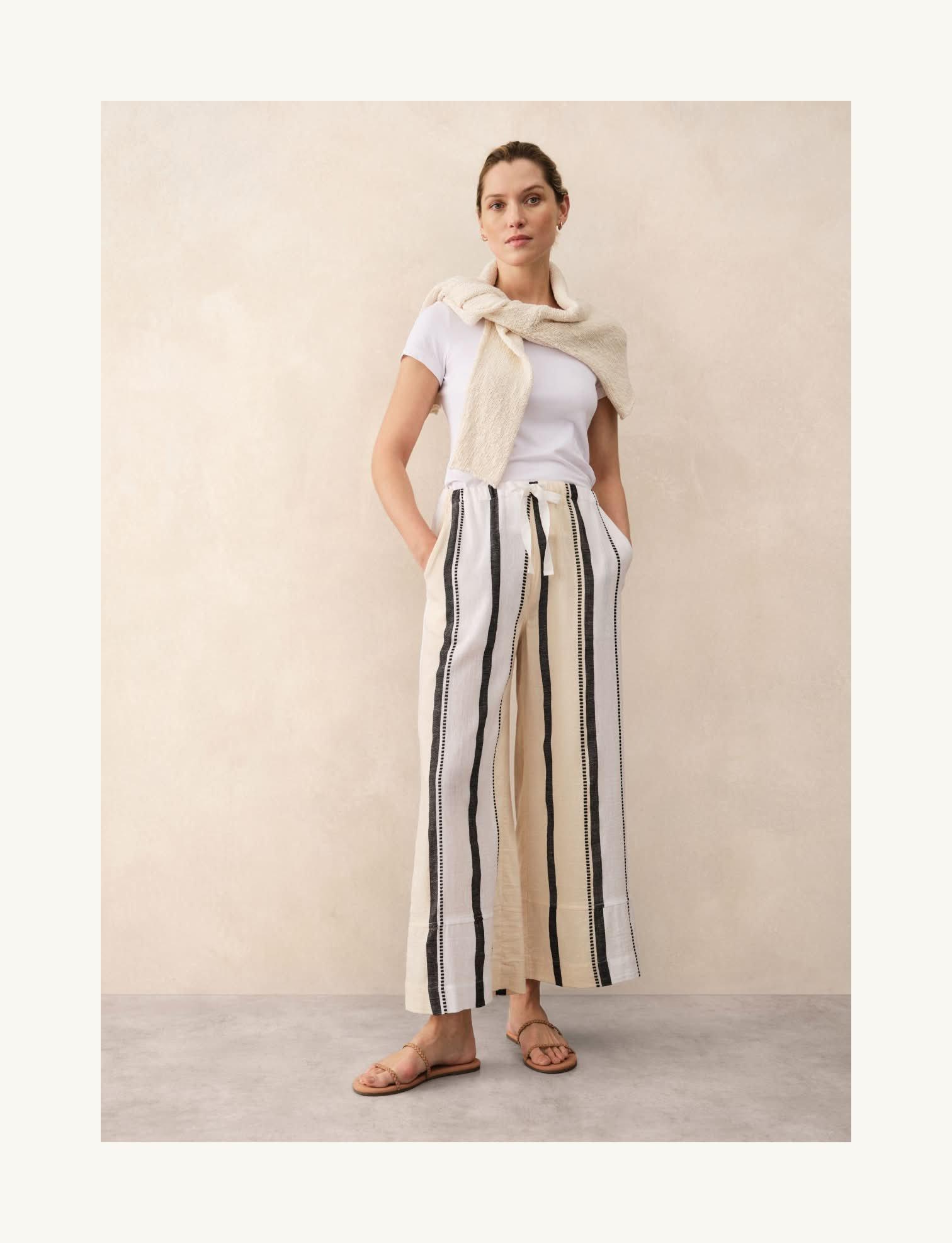 a woman in a white shirt and striped pants