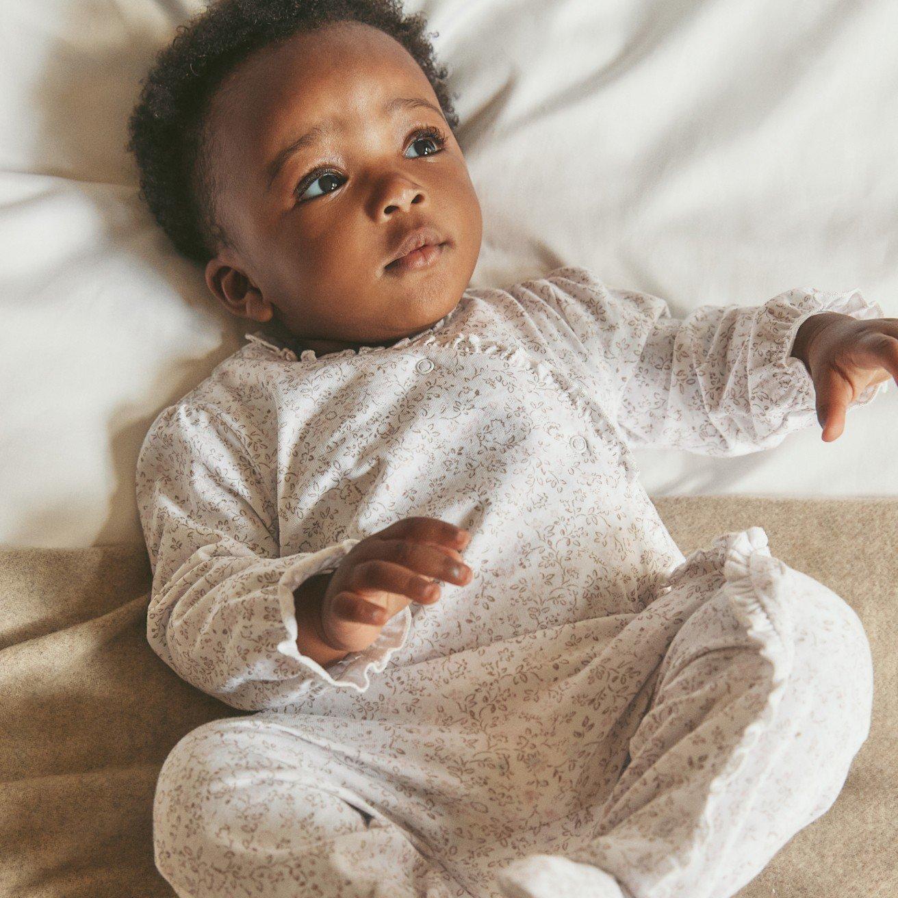a woman holding a baby and a toddler on a couch