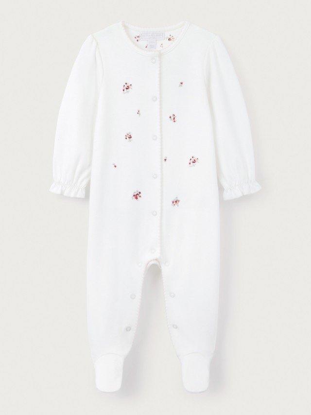 a baby's white footed sleepsuit with pink dots