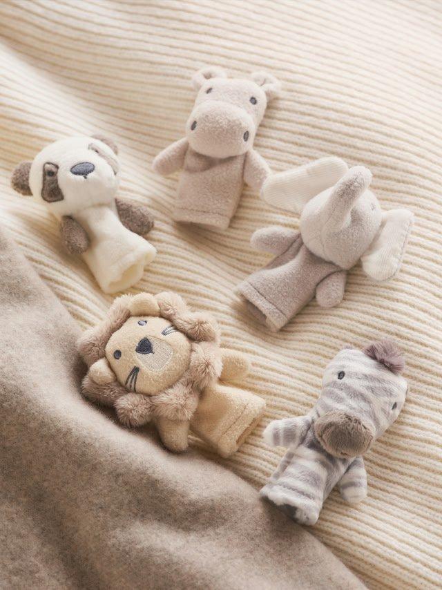 a group of stuffed animals laying on a bed with a blanket