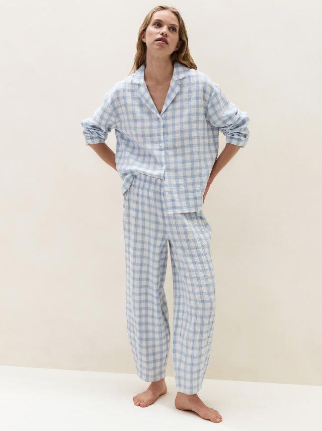 a woman in a blue and white checked pajama top and pants