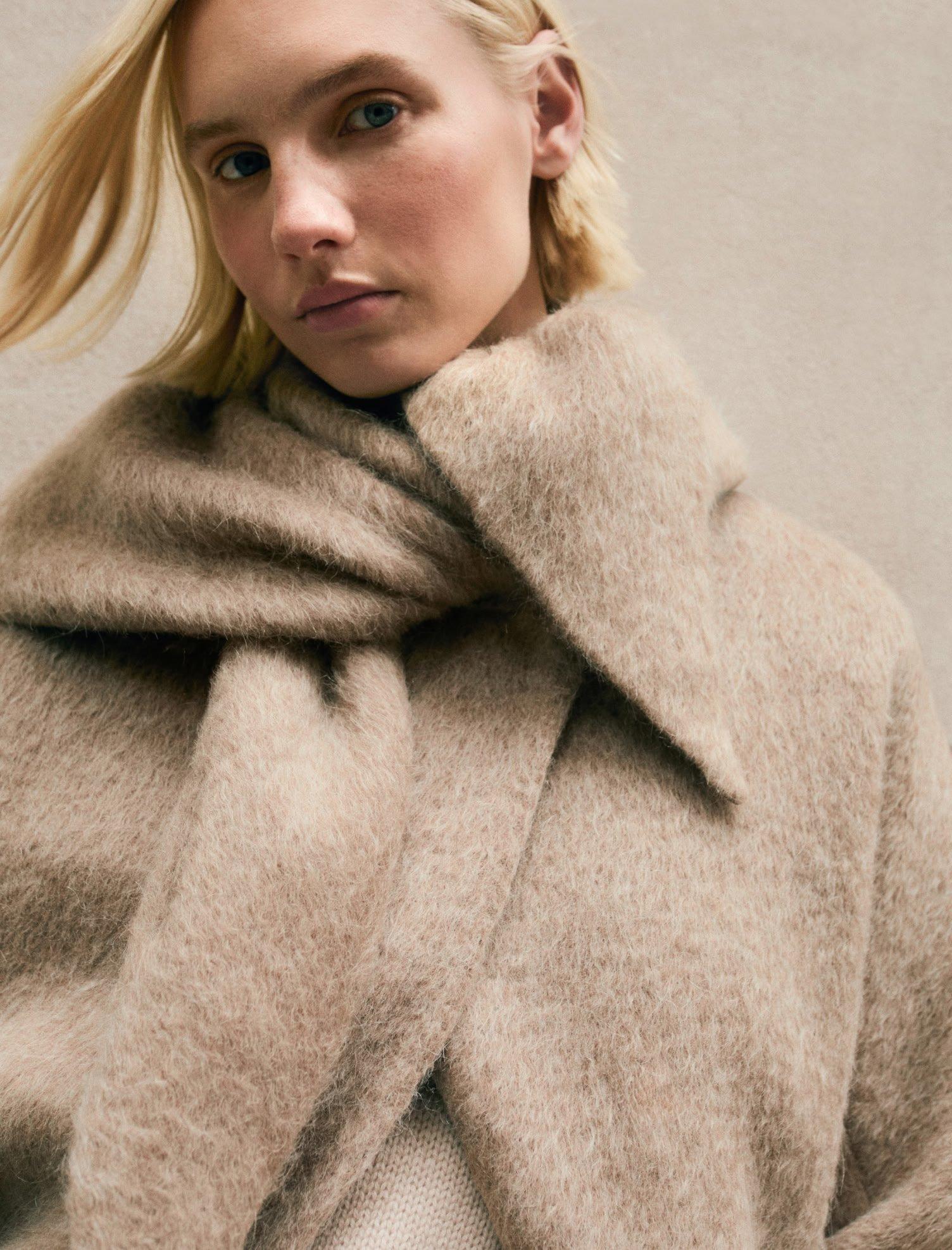 a woman with a scarf on her head and a sweater on
