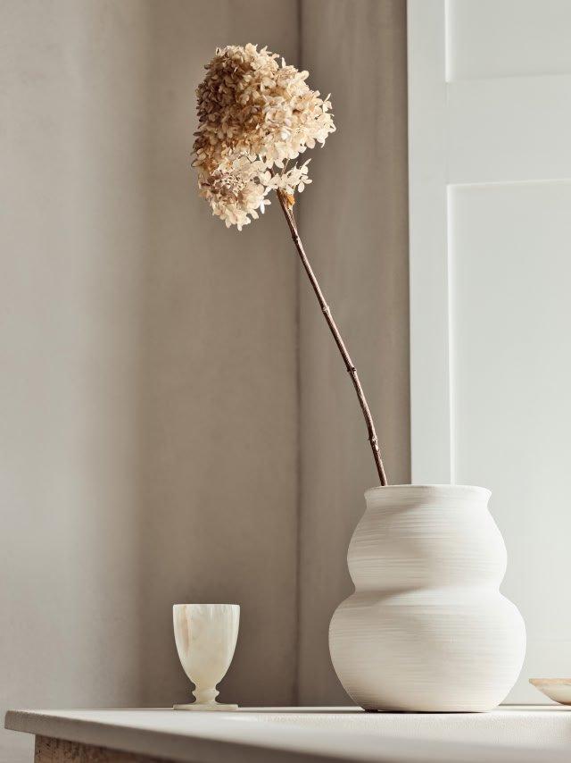 a vase with a flower in it on a table