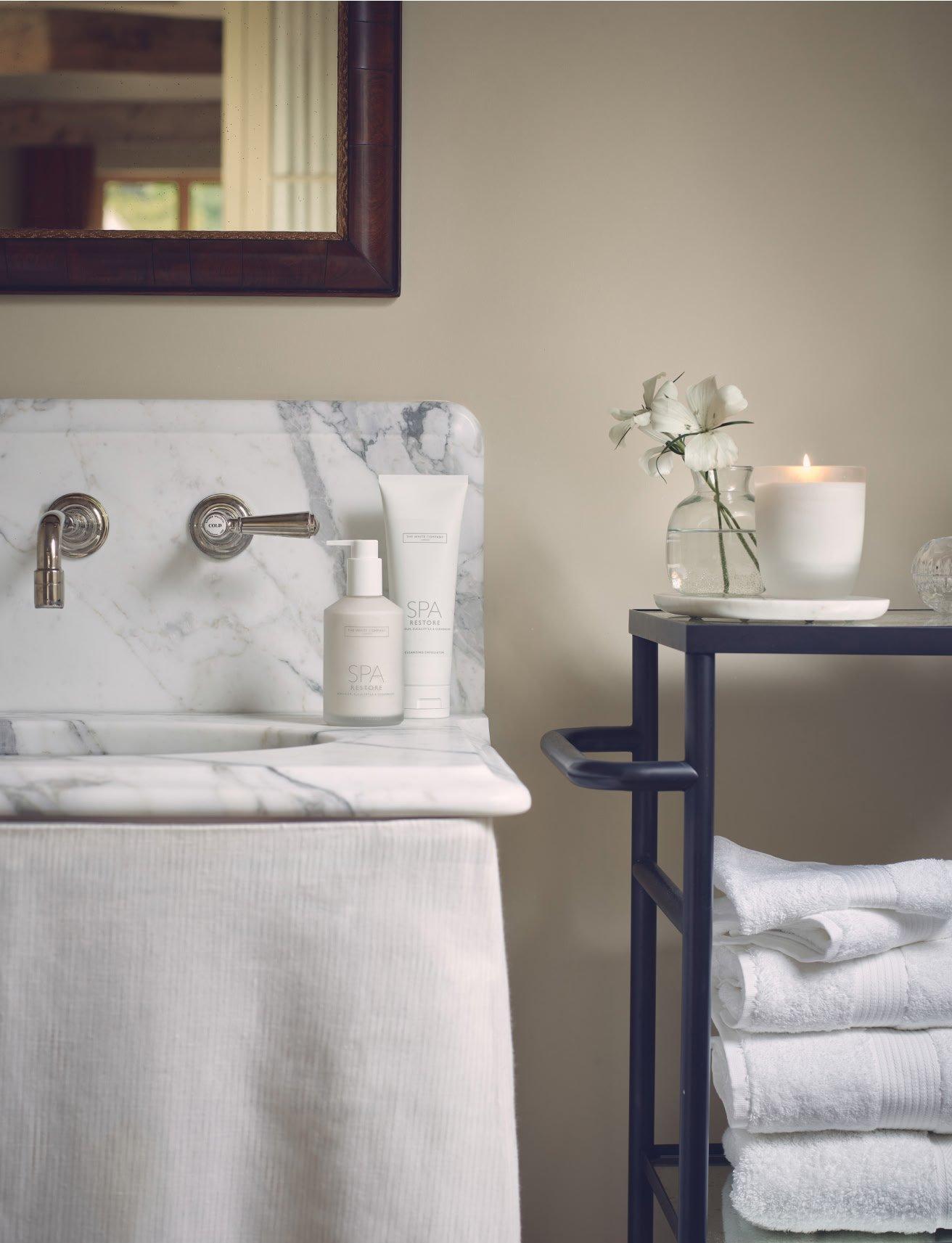 a bathroom with a sink, towel rack and a mirror