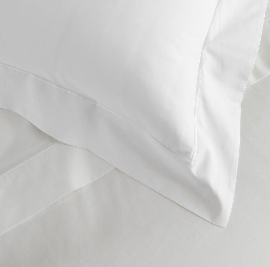 a close up of a white pillow on a bed