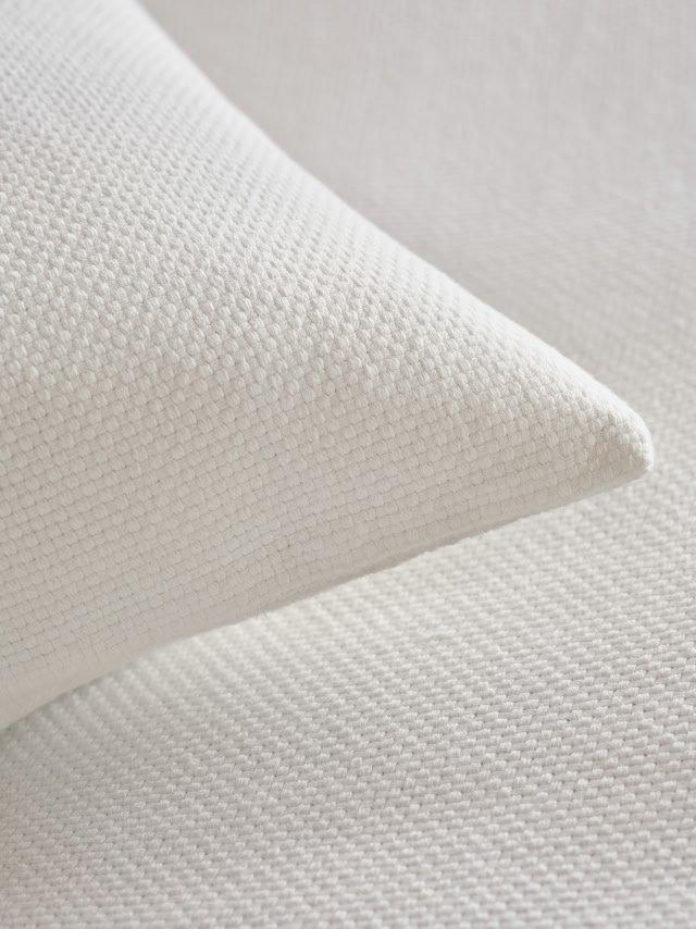 a close up of a white pillow on a bed