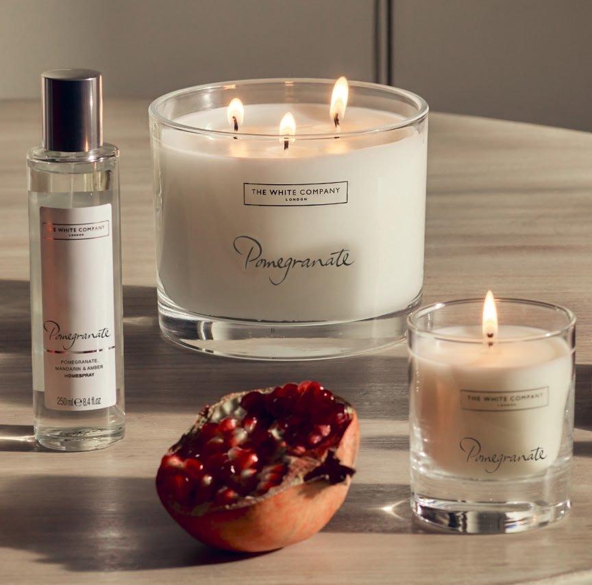 a table with three candles and a pomegranate on it
