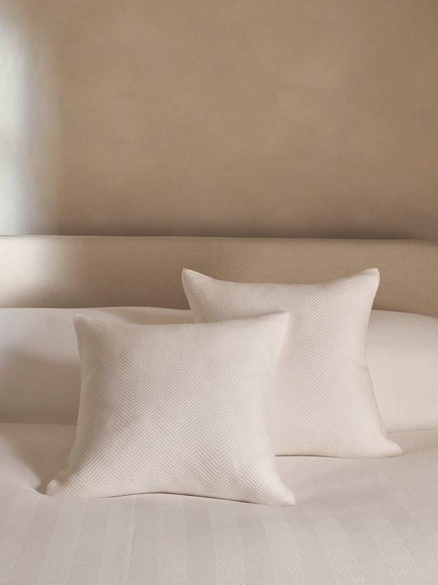 a bed with two pillows and a yellow ball on it