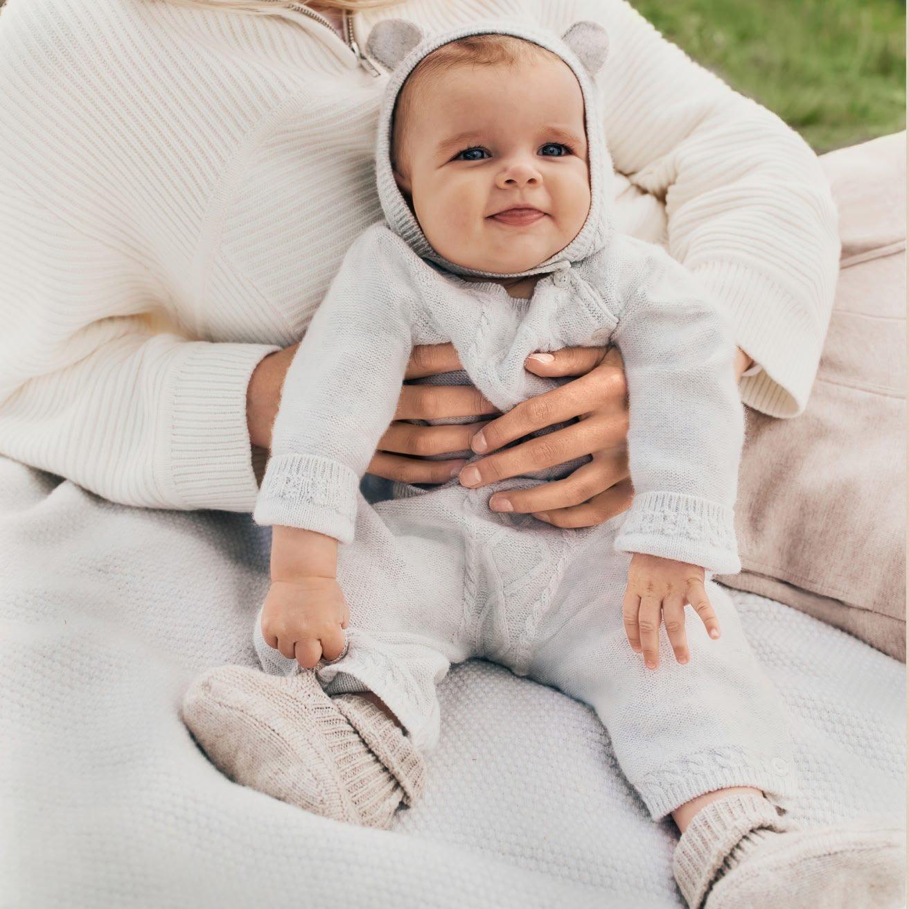 a baby crawling up a stairway in a white outfit