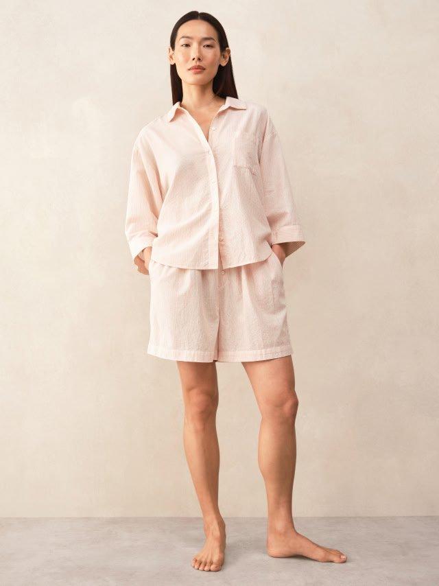 a woman in pink pajamas standing up