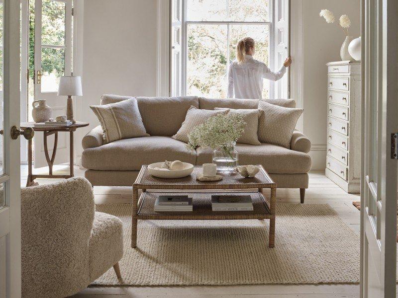 a woman standing in a living room looking out a window