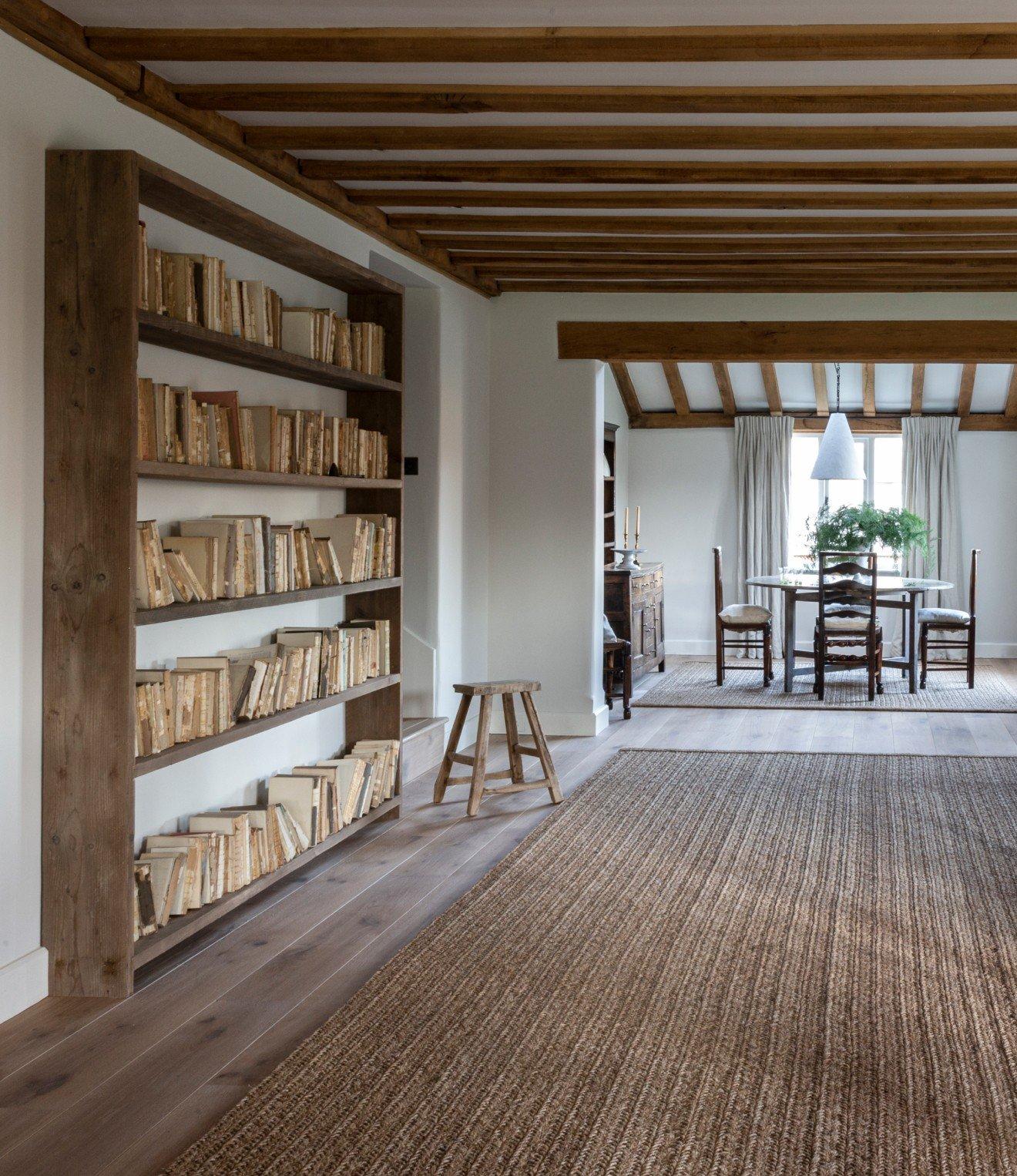 a large room with a table and chairs and a book shelf