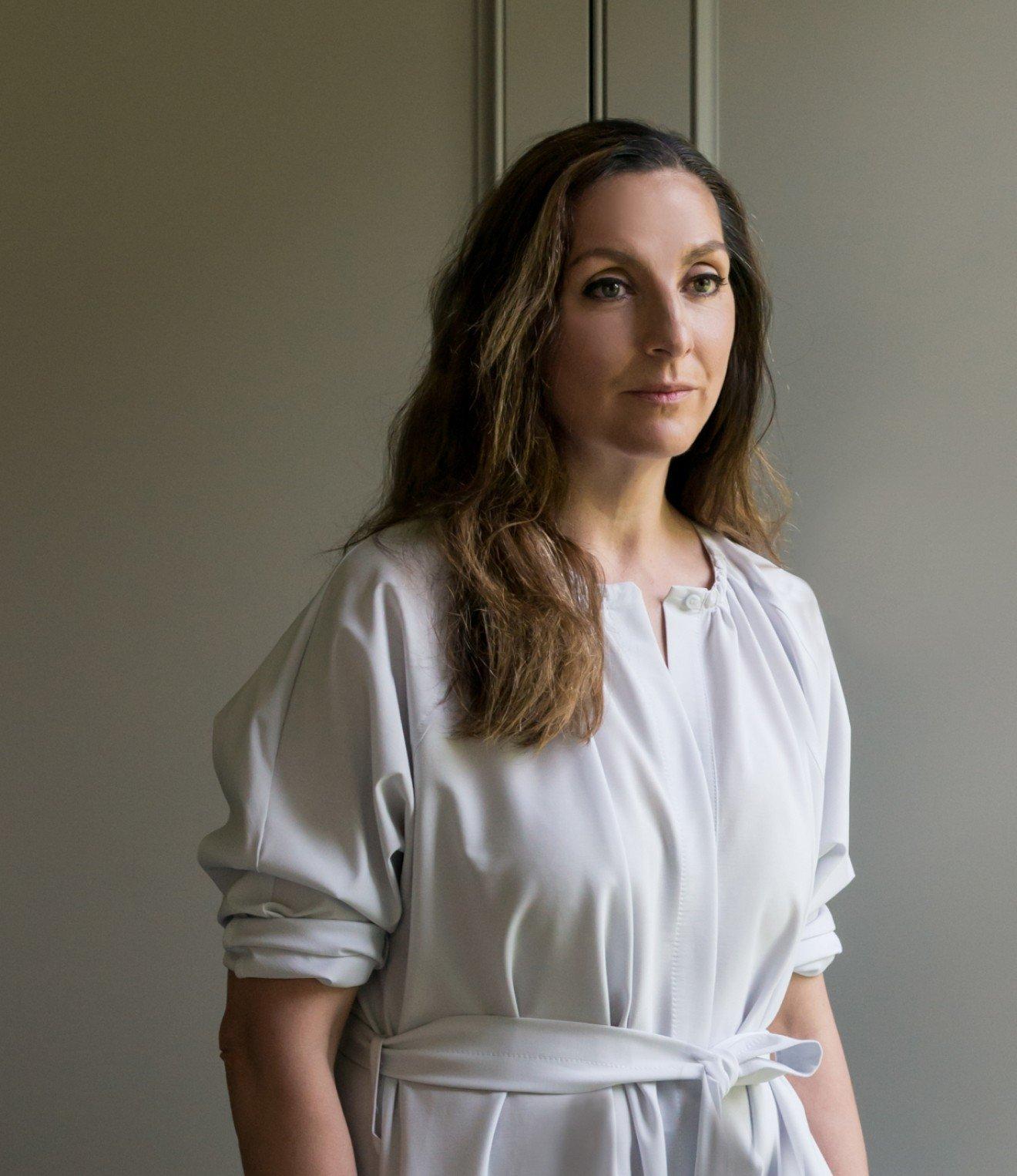 a woman standing in a room wearing a white dress