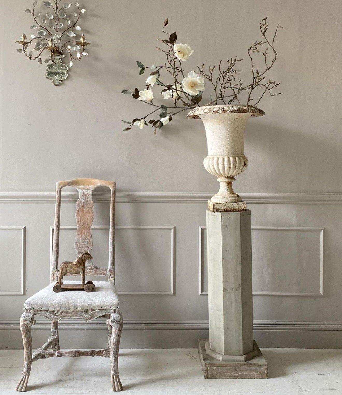 a chair sitting next to a vase with flowers in it