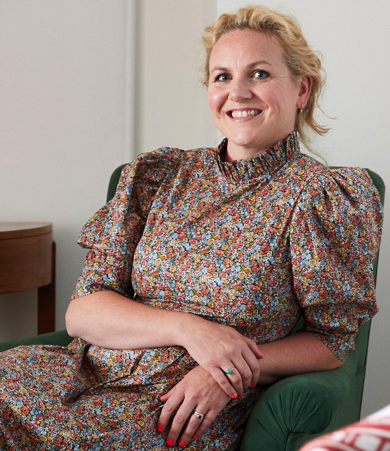 a woman sitting in a chair smiling at the camera