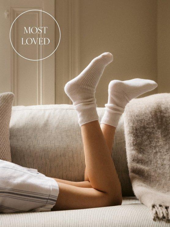 a woman laying on a couch with her legs crossed