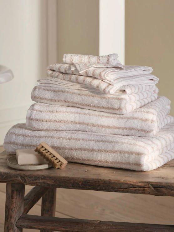 a stack of towels on a wooden table with a soap dish