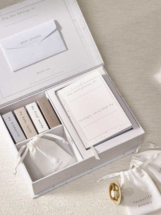 a white box with a white ribbon and a white bag