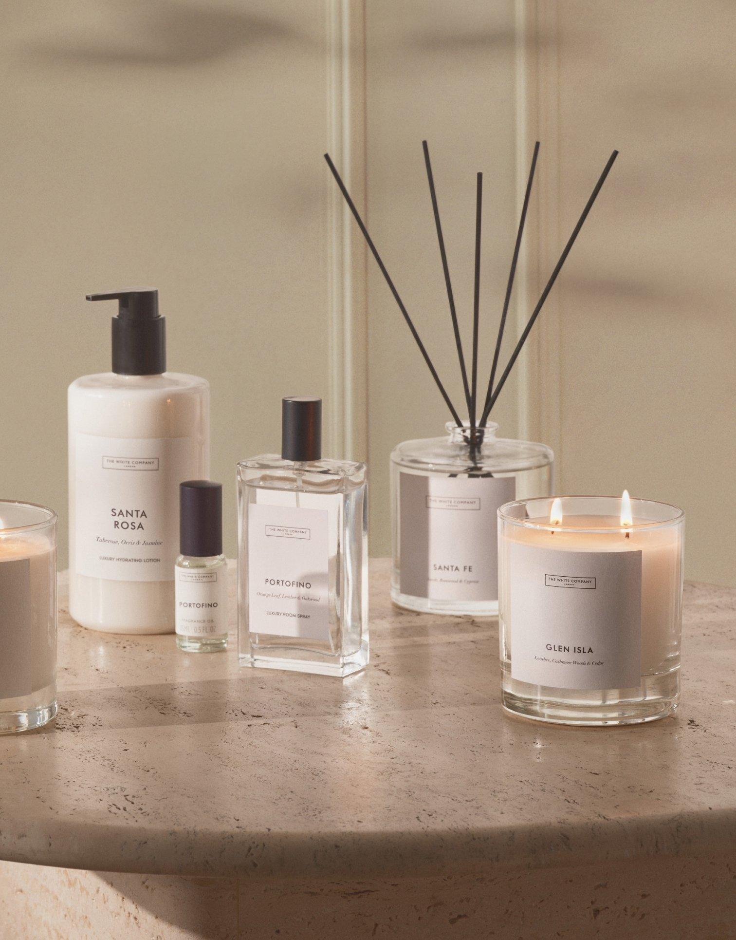 a table with a bunch of candles and perfumes on it