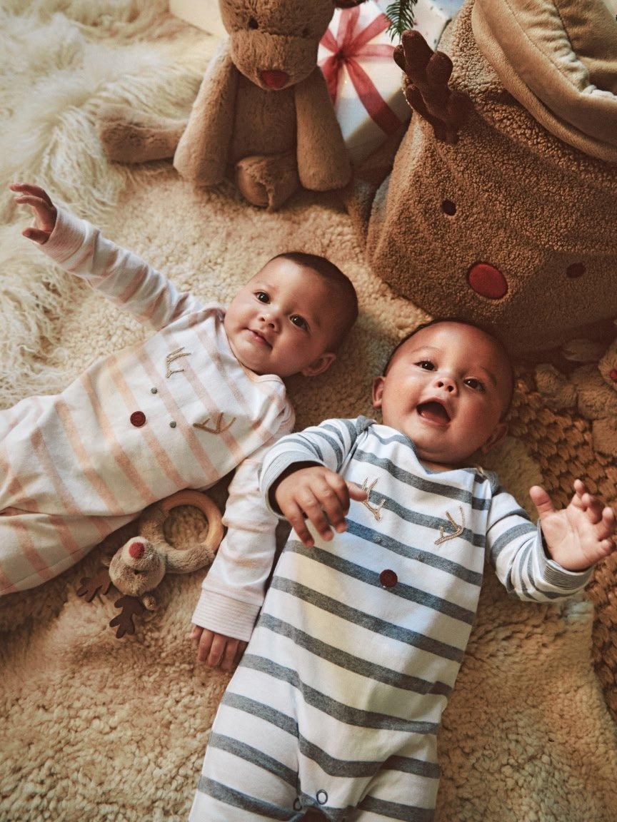 a baby sitting on the floor with a toy giraffe
