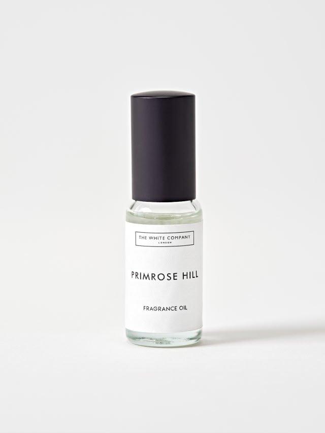 a bottle of oil next to a bowl of tonka beans