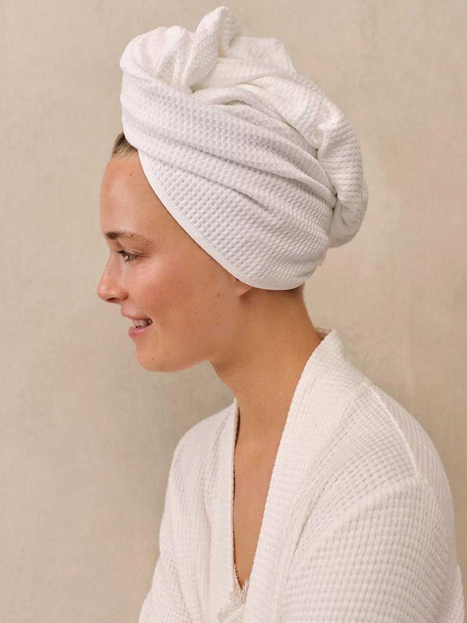 a woman in a white robe with a towel on her head