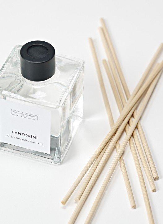 a bottle of perfume and sticks of incense on a table