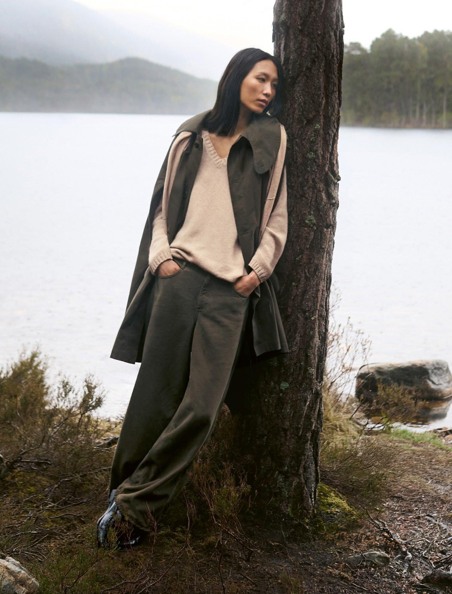 woman leaning on tree