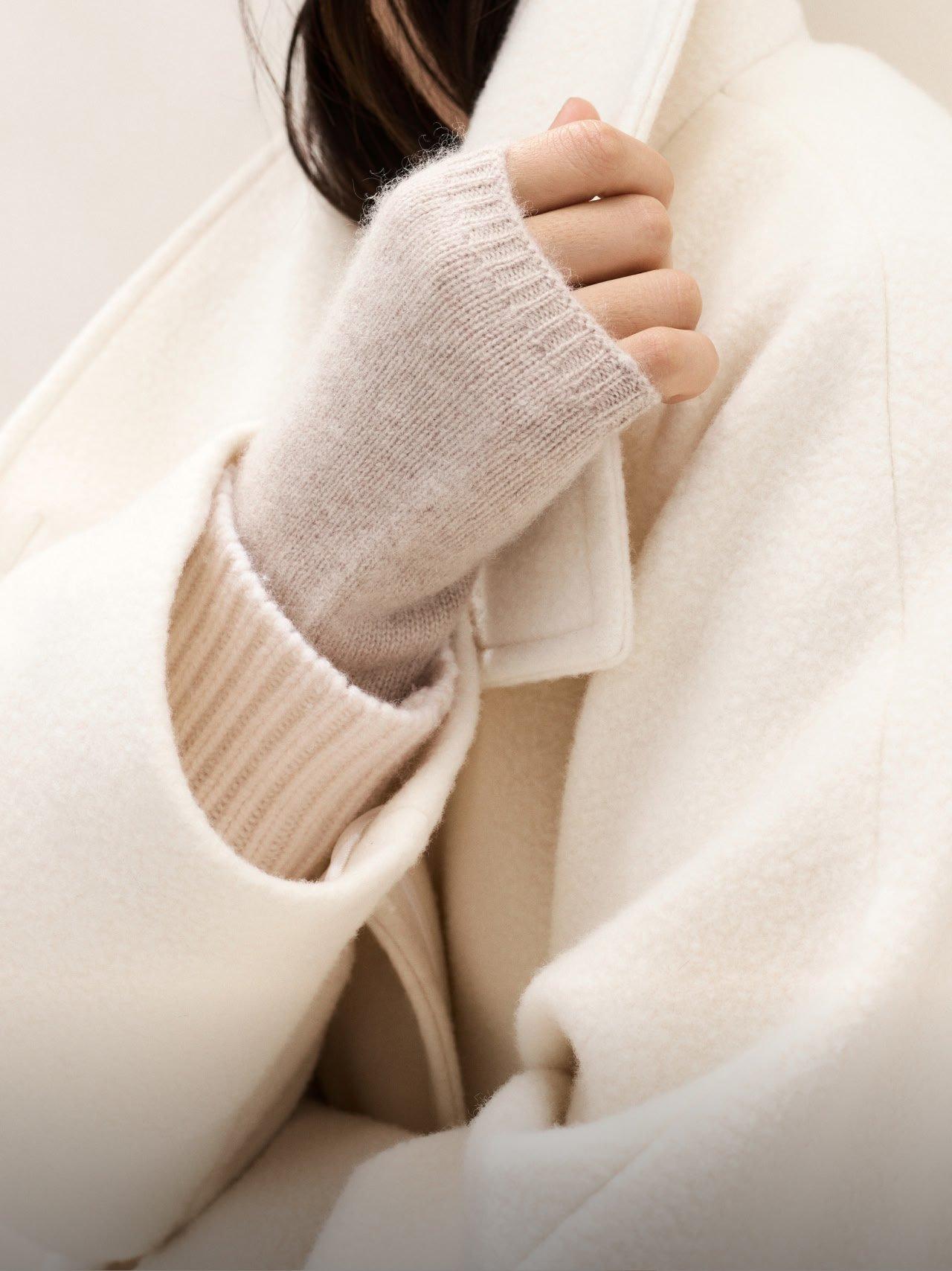 a woman in a white coat with gloves on her hands
