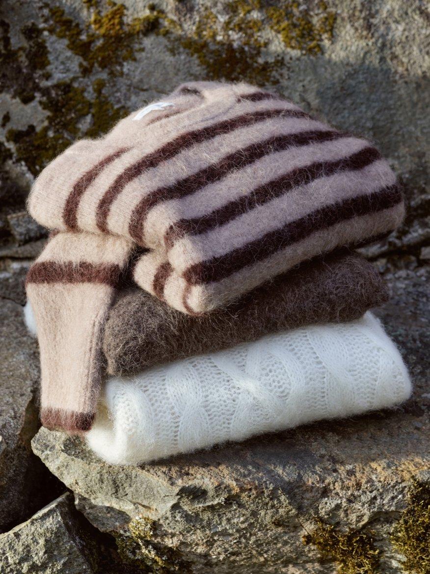 a pile of three sweaters stacked on top of each other