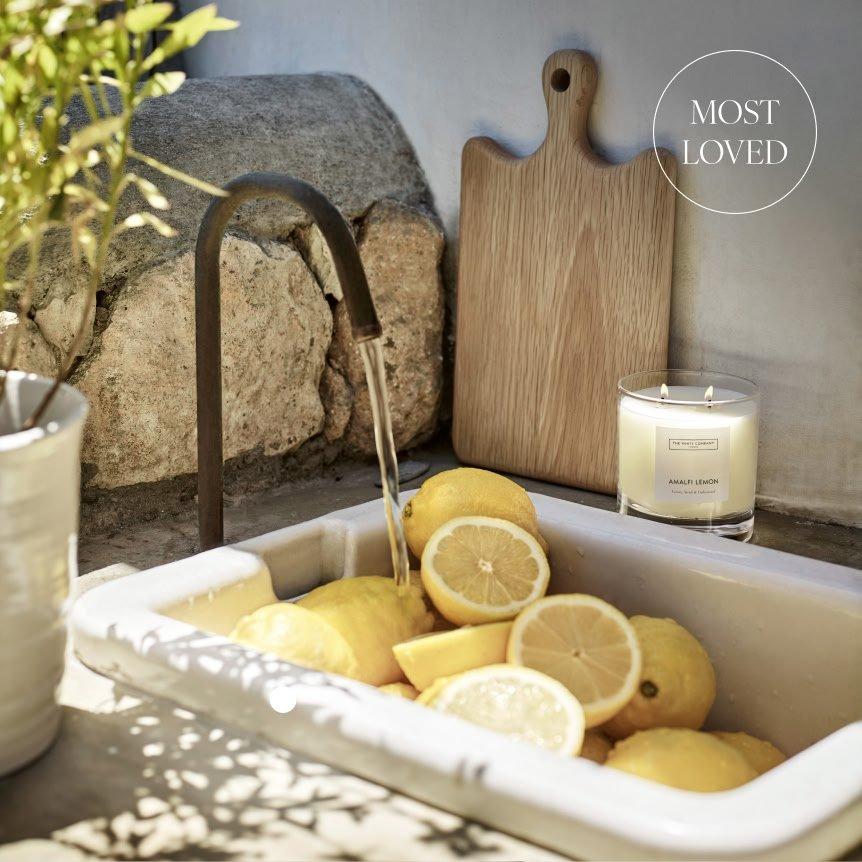 a sink filled with lemons and a candle next to it