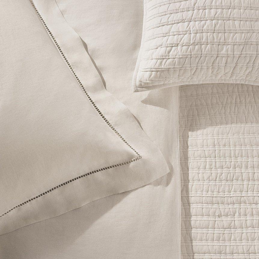 a close up of a bed with pillows and a blanket