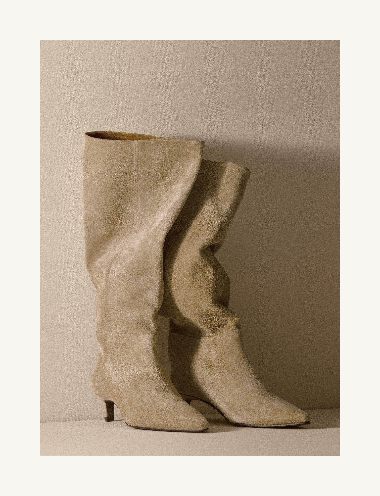a pair of white boots sitting on top of a white surface