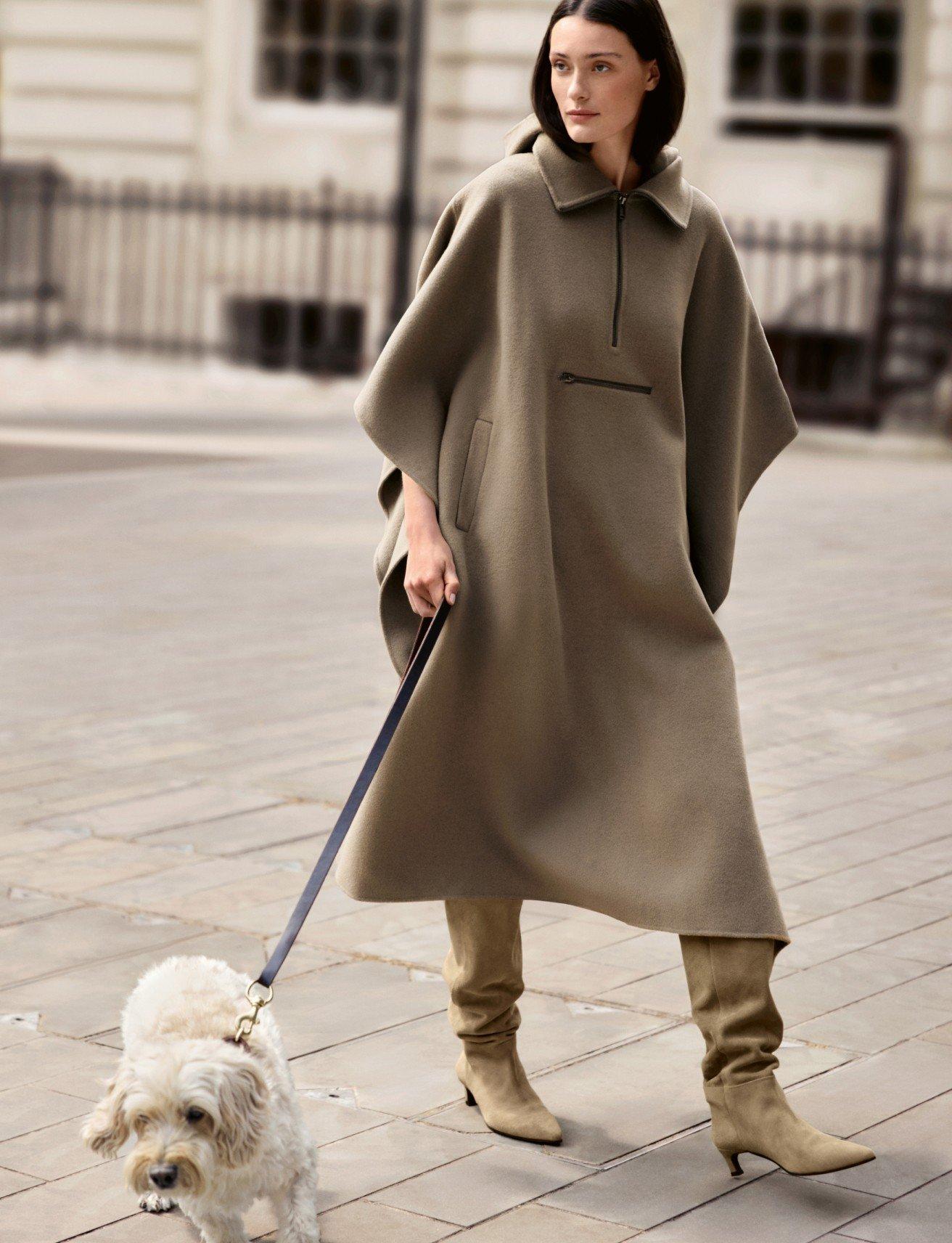 a woman walking a small dog on a leash