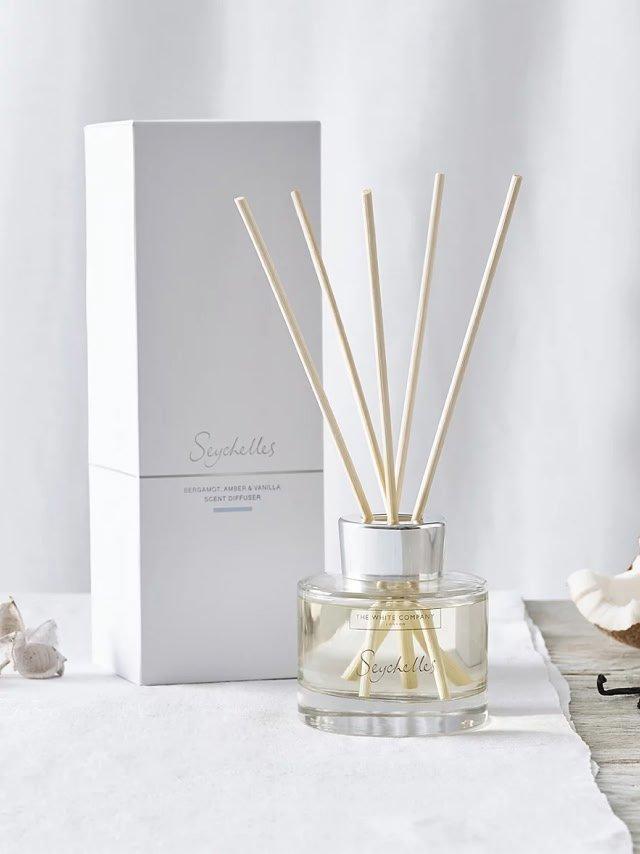 a reed diffuser with a white box next to it