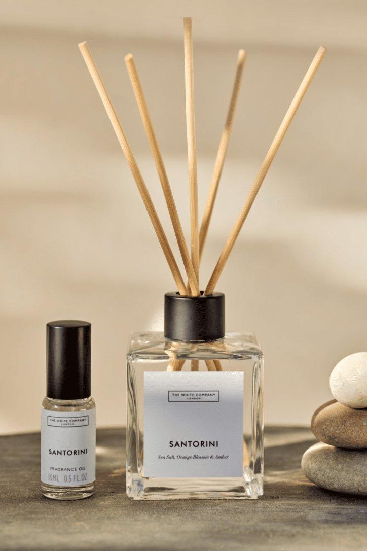 two reed diffusers are sitting on a white cloth on a table