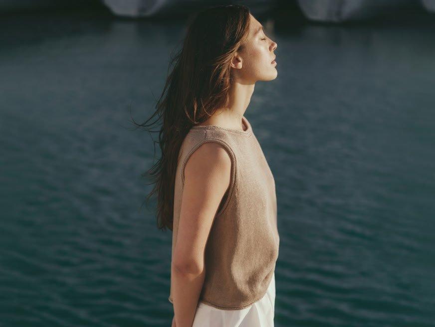 a woman standing on a dock looking out over the water