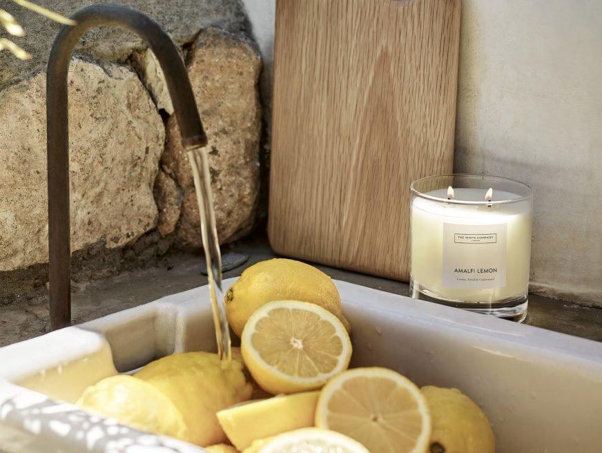a sink filled with lemons and a candle next to it