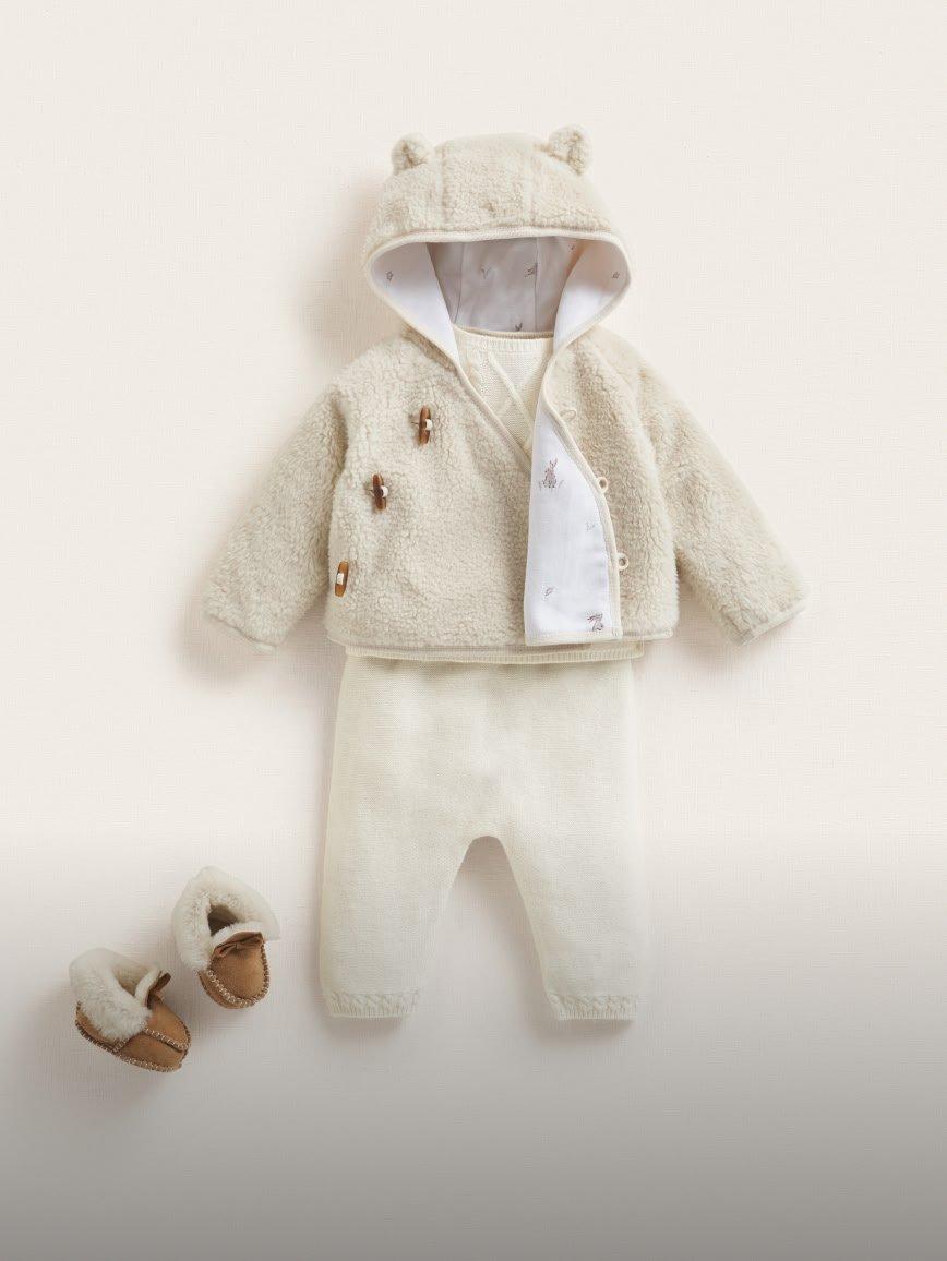 a baby outfit with a hood and shoes on a white surface